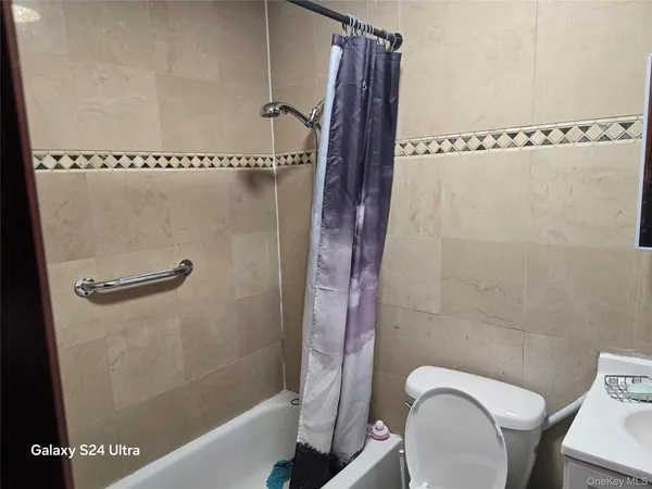 a bathroom with a shower a toilet and a sink