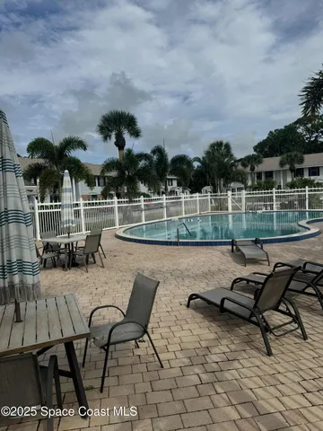 a view of a patio with dining table and chairs with plants