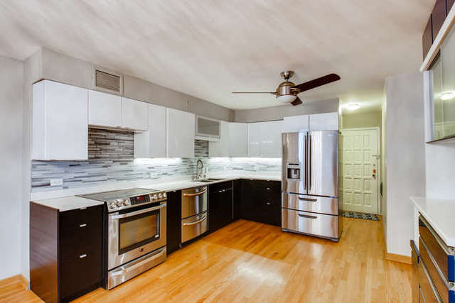 6147 North Sheridan Road, Unit 16A Chicago, IL 60660 - Photo 11 of 30 a kitchen with granite countertop a stove a sink and a refrigerator