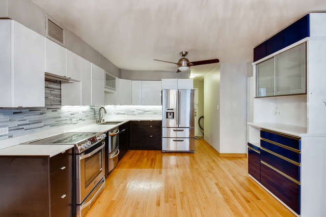 6147 North Sheridan Road, Unit 16A Chicago, IL 60660 - Photo 14 of 30 a kitchen with stainless steel appliances granite countertop a sink and wooden cabinets
