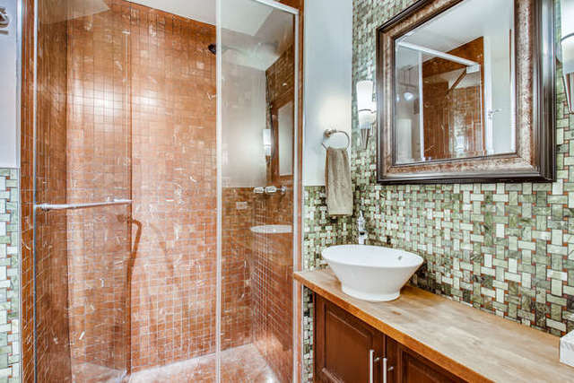 6147 North Sheridan Road, Unit 16A Chicago, IL 60660 - Photo 21 of 30 a bathroom with a granite countertop sink a mirror and shower