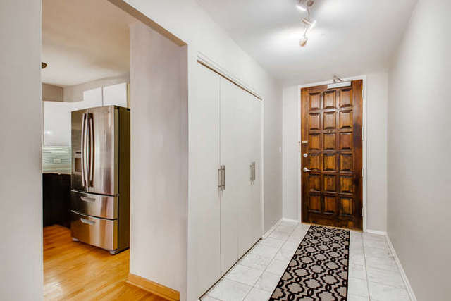6147 North Sheridan Road, Unit 16A Chicago, IL 60660 - Photo 5 of 30 a kitchen with stainless steel appliances wooden cabinet and a refrigerator
