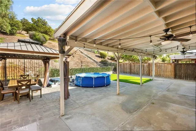 a view of a swimming pool with a patio and a yard
