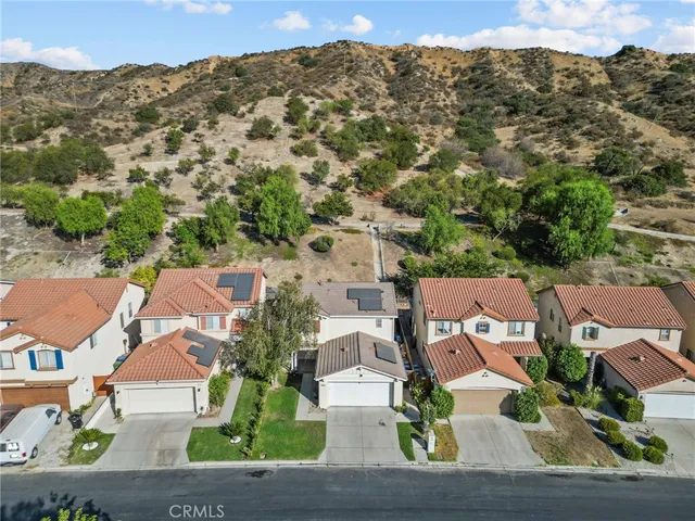 an aerial view of a house with a mountain