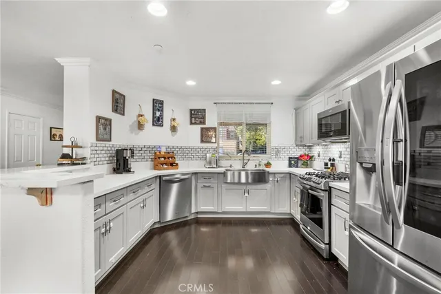 a kitchen with white cabinets and stainless steel appliances