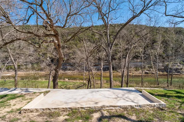 a view of a yard in front of a house with large tree