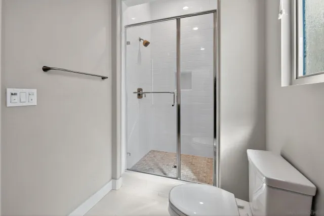 a bathroom with a granite countertop toilet a sink and shower