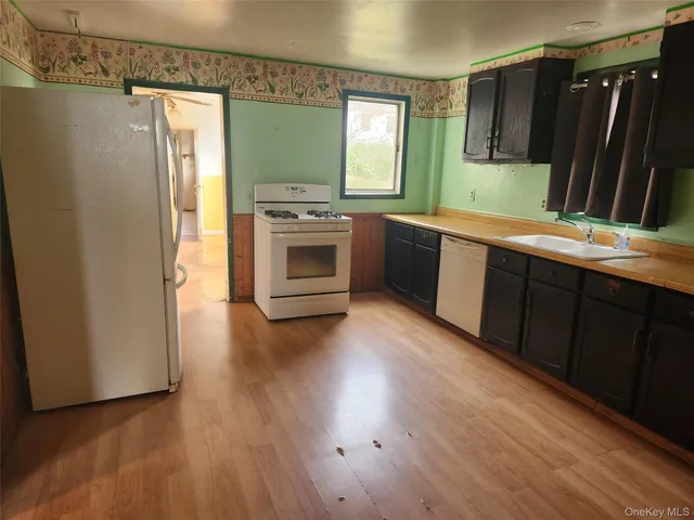 a kitchen with white cabinets and wooden floor