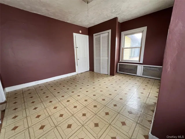 a view of an empty room with a fireplace and window