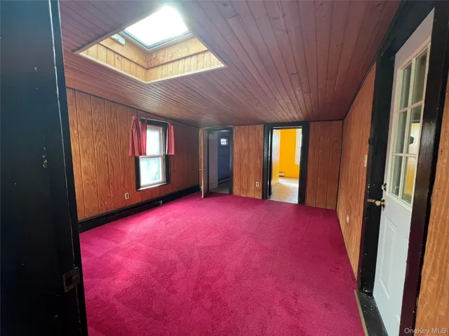 a view of an empty room with a fireplace and window