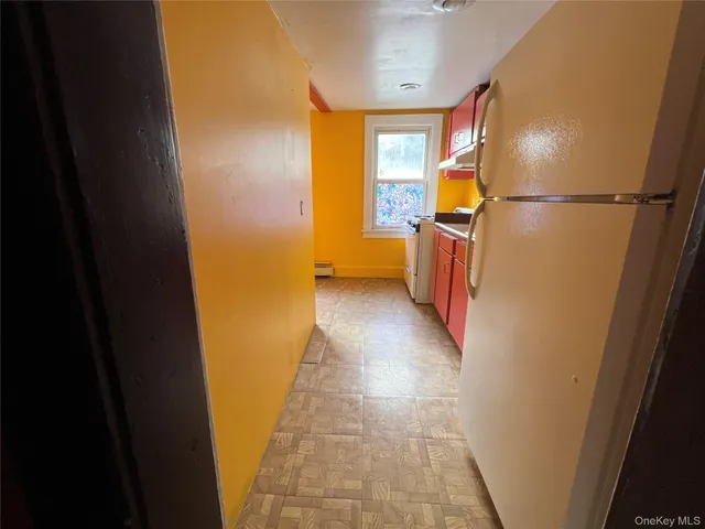 a view of a hallway with wooden floor and a bathroom