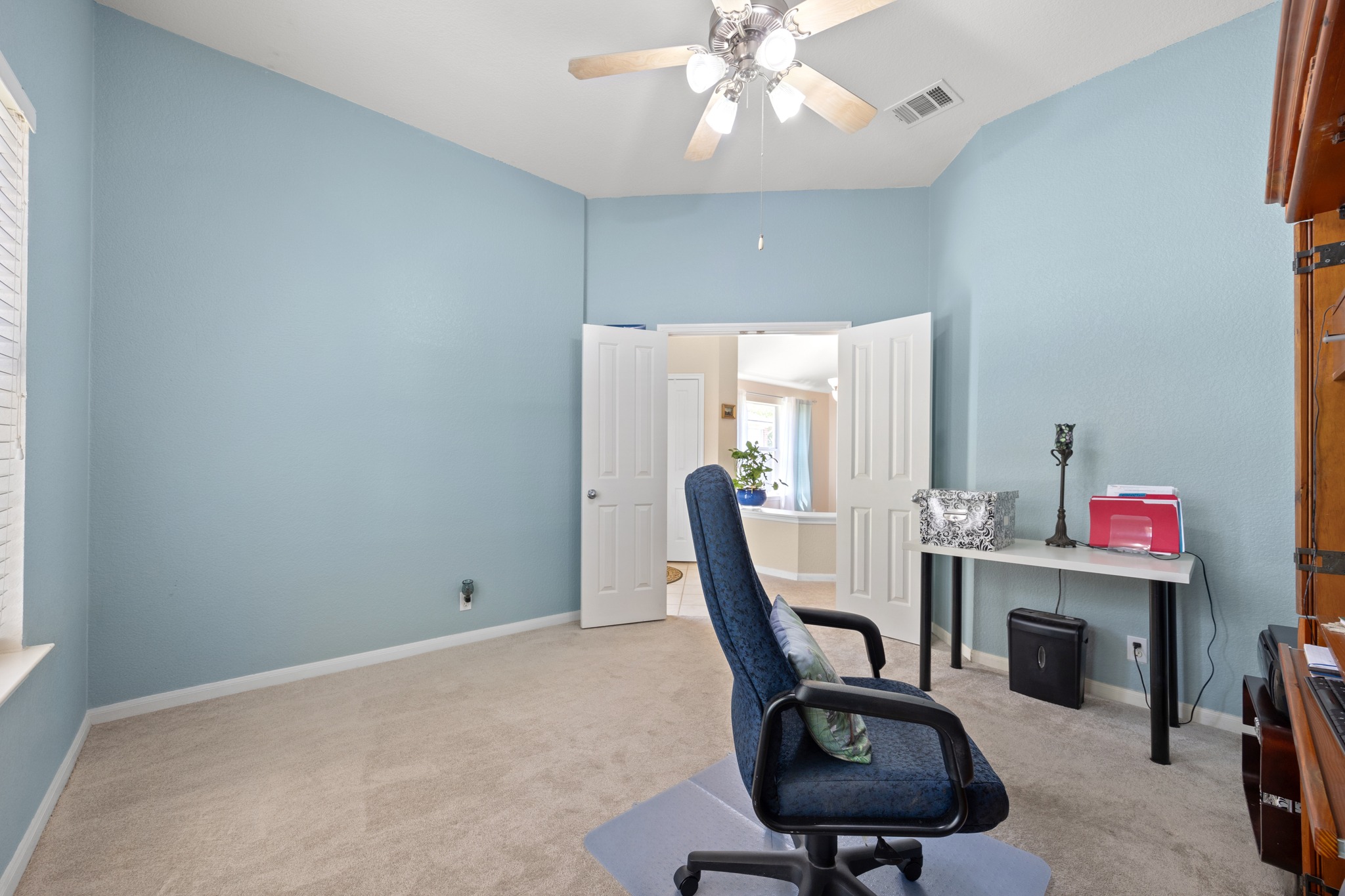 1108 Springbrook Road Pflugerville, TX 78660 - Photo 7 of 37 A versatile office space features a vaulted ceiling and direct access to an adjacent room, ideal for productivity.