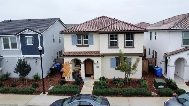 a front view of a house with plants