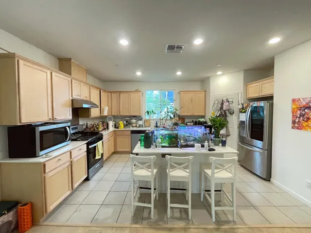 a kitchen with stainless steel appliances kitchen island granite countertop a sink and cabinets