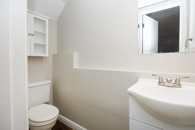 a bathroom with a toilet a sink and mirror