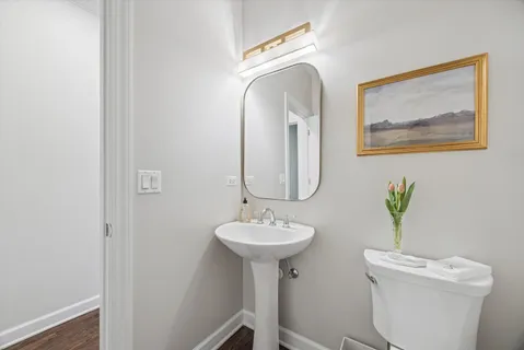 a bathroom with a toilet a sink and a mirror