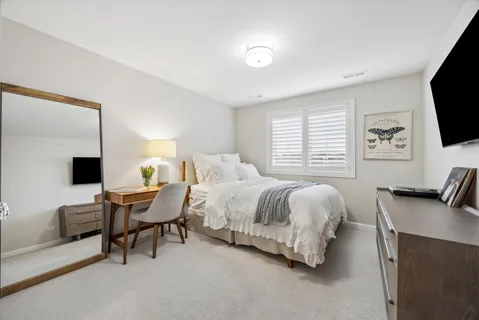 a spacious bedroom with a bed and a flat screen tv