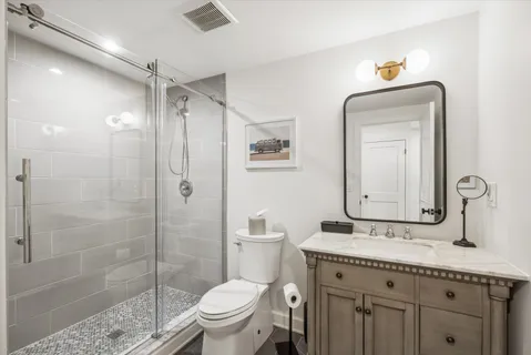 a bathroom with a granite countertop sink toilet and shower