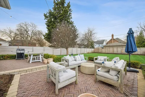 a view of a patio with couches and a table and chairs with wooden fence