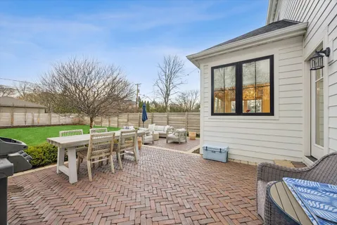 a view of a patio with table and chairs next to a yard