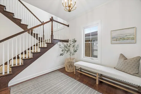a living room with wooden floor and a potted plant