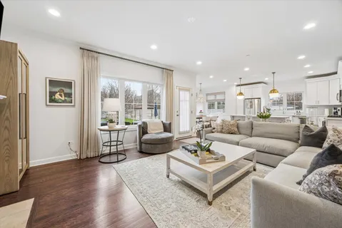 a living room with furniture wooden floor and a large window