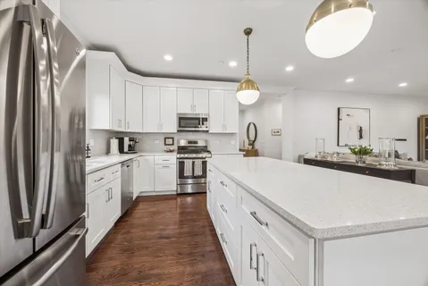 a large white kitchen with stainless steel appliances