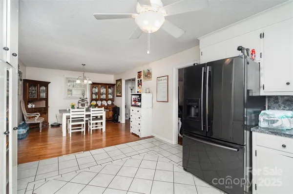 a kitchen with granite countertop a refrigerator a stove top oven and cabinets
