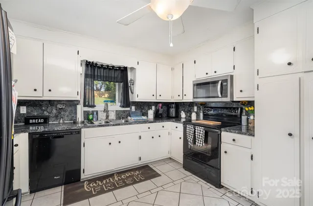 a kitchen with granite countertop white cabinets and white appliances