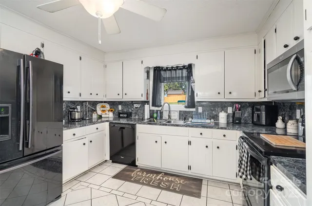 a kitchen with granite countertop a sink stove and refrigerator