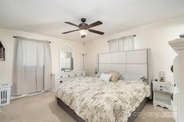 a bedroom with a large bed and a chandelier