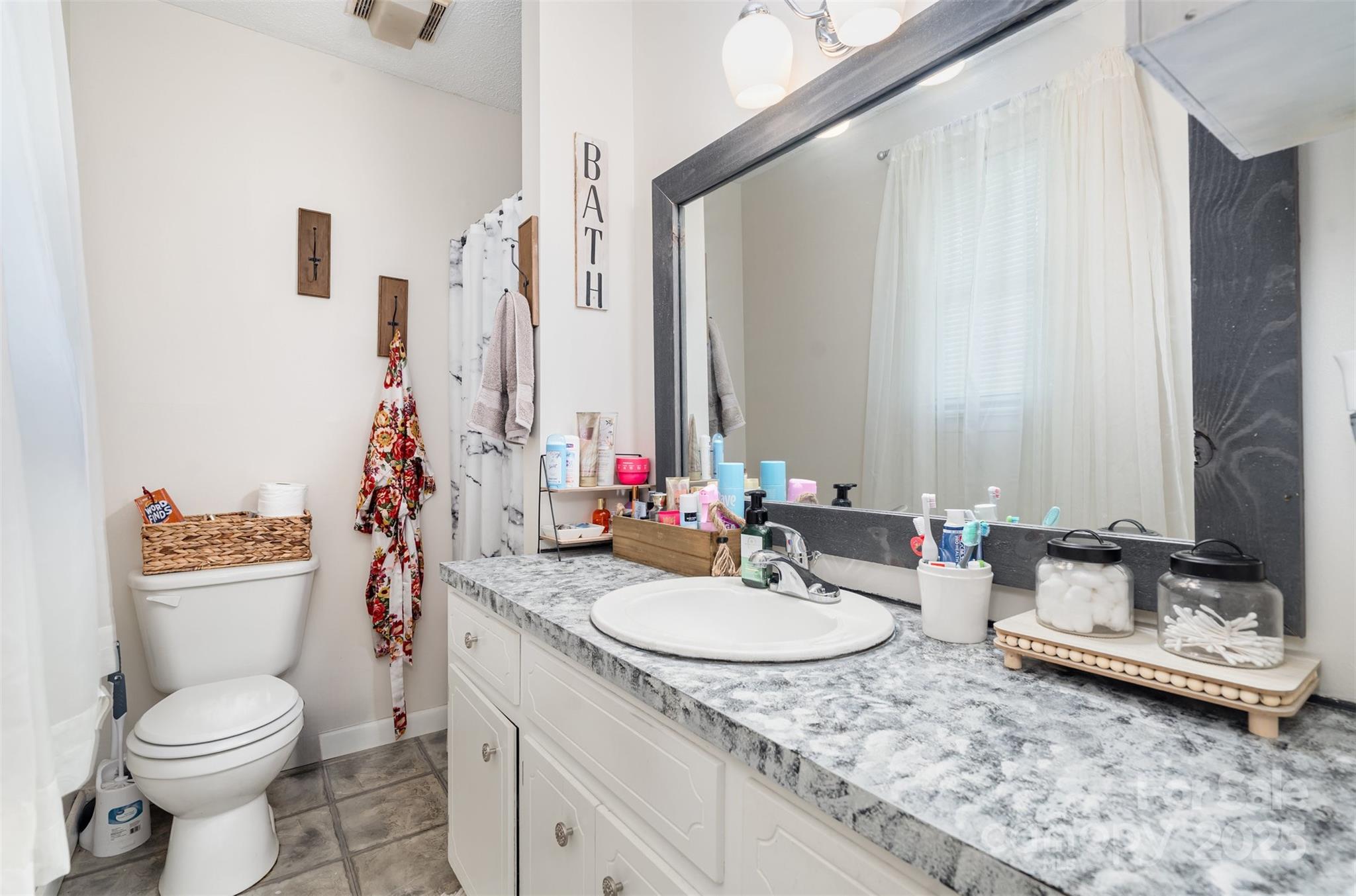 5609 Grace Chapel Road Hickory, NC 28601 - Photo 16 of 29 a bathroom with a granite countertop sink toilet and mirror
