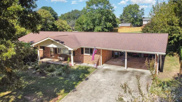 aerial view of house with yard and trees in the background