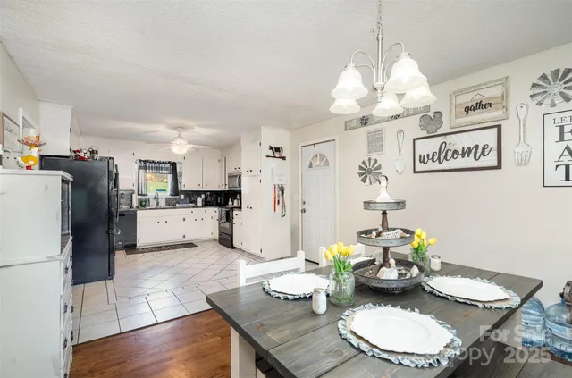 a kitchen with stainless steel appliances kitchen island granite countertop a dining table a stove a microwave and a refrigerator