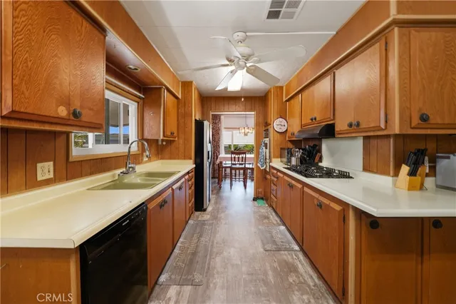 a large kitchen with stainless steel appliances granite countertop a sink counter space cabinets and a large window