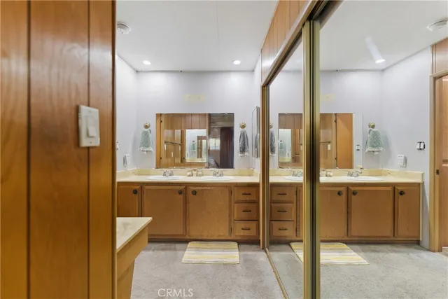 a bathroom with a double vanity sink and mirror with shower
