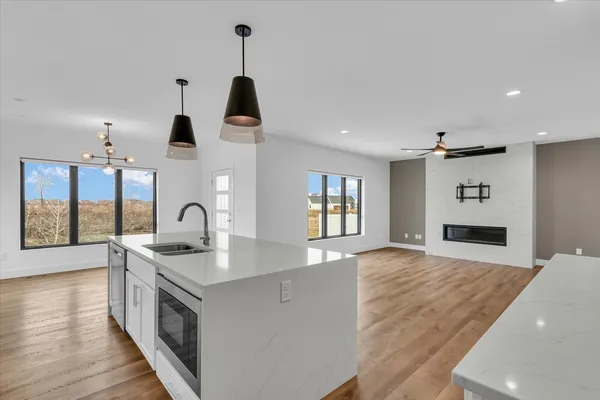 a kitchen with stainless steel appliances granite countertop a sink a stove and a wooden floors