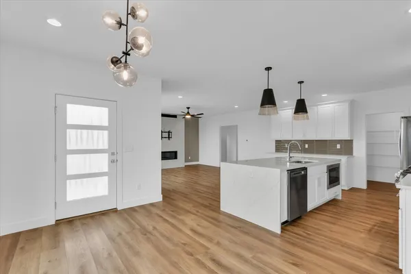 a large kitchen with cabinets wooden floor and stainless steel appliances