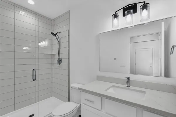 a bathroom with a sink a toilet and shower
