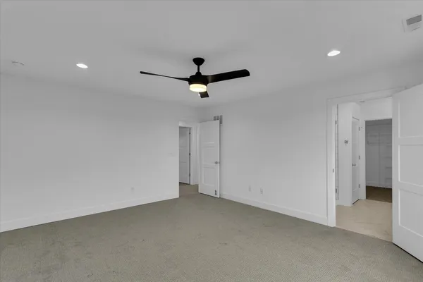 an empty room with ceiling fan and window