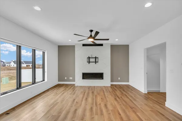 a view of empty room with wooden floor and fireplace