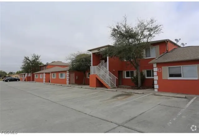 a view of a house with a yard and large tree