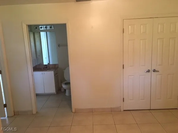 an empty room with closet and mirror