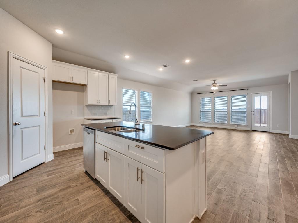 930 Waterview Drive Prosper, TX 75078 - Photo 8 of 17 a kitchen with stainless steel appliances granite countertop a stove a sink and a granite counter tops with wooden floors