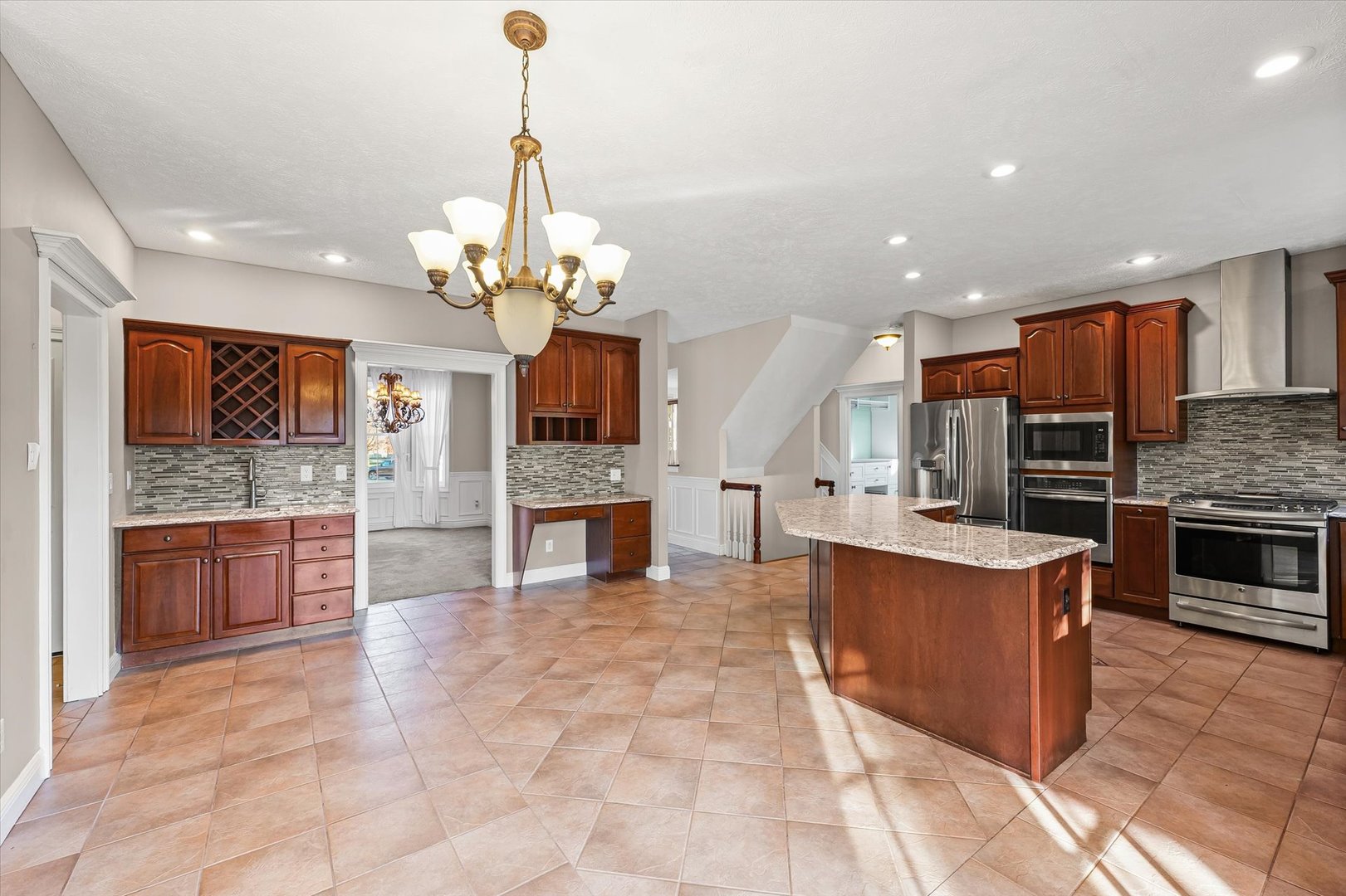 1 Windsong Way Bloomington, IL 61704 - Photo 13 of 90 a large kitchen with stainless steel appliances kitchen island granite countertop a stove top oven a sink dishwasher a dining table and chairs with wooden floor