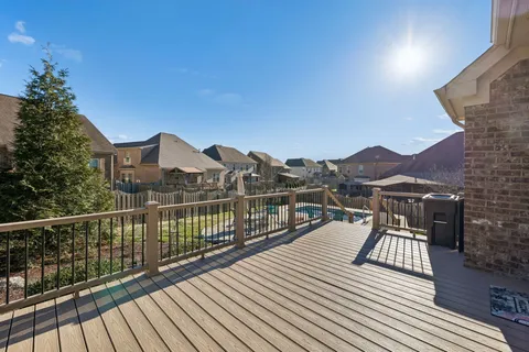 an empty room with wooden floor fireplace and windows