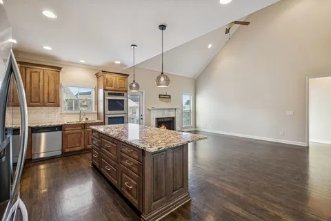 a kitchen with stainless steel appliances granite countertop a stove and a wooden cabinets