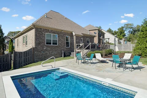a view of a house with backyard and sitting area