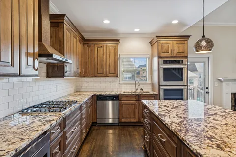a kitchen with kitchen island granite countertop a sink stove and refrigerator