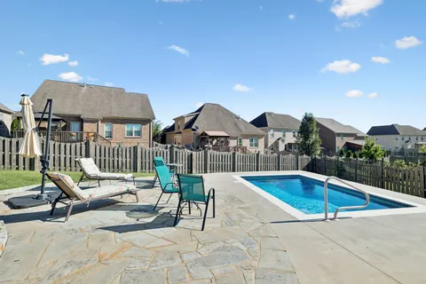 a house view with swimming pool in front of it